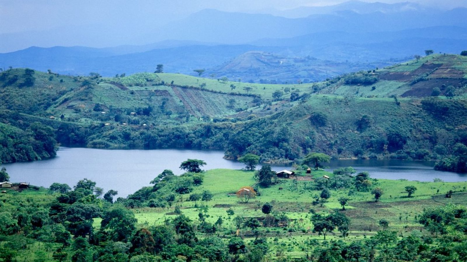 Deep blue crater lake ringed by forest, Fort Portal